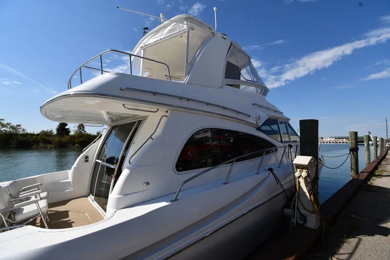 Slide: The Image of 2003 Cruisers Yachts 5000 Sedan Sport docked by the water on a sunny day. - 6