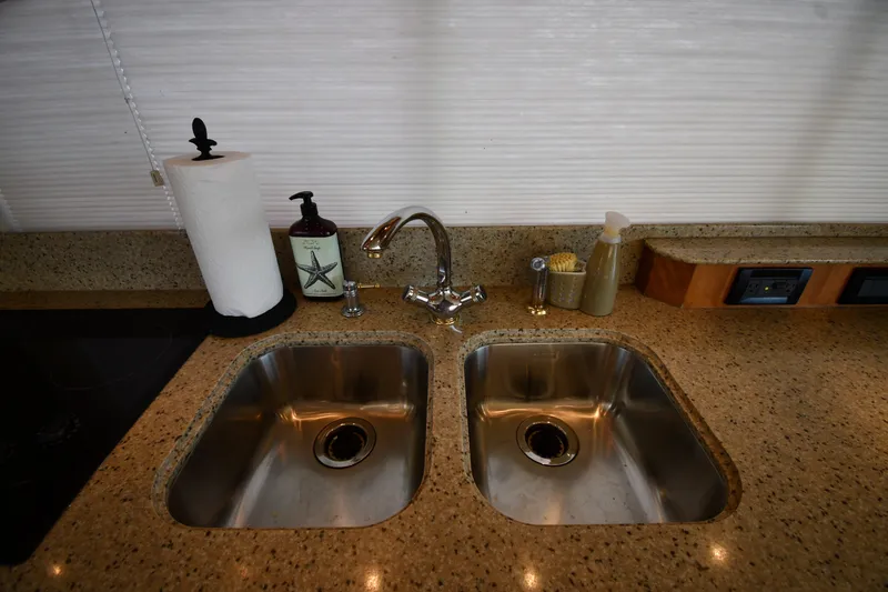 Slide: The Image of Luxury yacht kitchen sink area with granite countertop, dual sinks, and modern fixtures, 2003 Cruisers Yachts. - 62