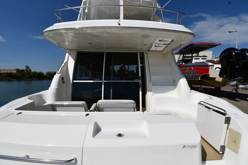 Slide: The Image of 2003 Cruisers Yachts 5000 Sedan Sport, rear view, docked by the water. - 12