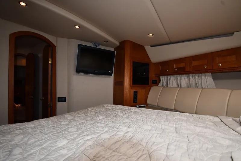 Slide: The Image of Luxurious bedroom interior of 2003 Cruisers Yachts 5000 Sedan Sport with TV and wood accents. - 40