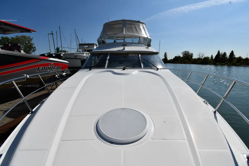 Slide: The Image of 2003 Cruisers Yachts 5000 Sedan Sport docked by the water. - 10