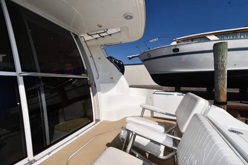 Slide: The Image of 2003 Cruisers Yachts 5000 Sedan Sport interior with seating, docked beside another boat. - 15