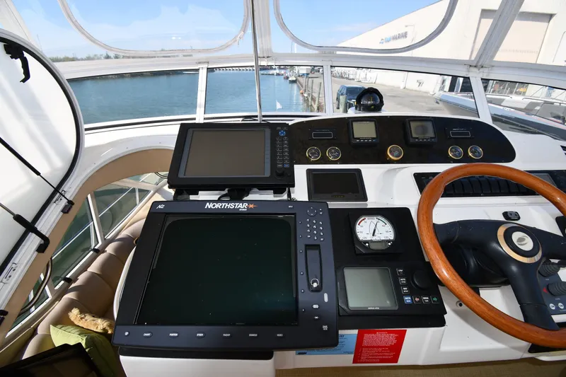 Slide: The Image of Helm of 2003 Cruisers Yachts 5000 Sedan Sport with navigation equipment and wooden steering wheel. - 24
