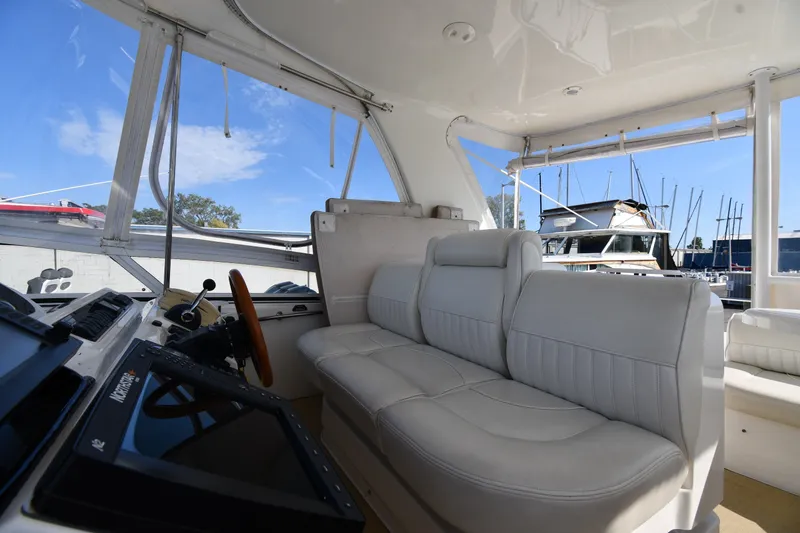 Slide: The Image of Interior of 2003 Cruisers Yachts 5000 Sedan Sport with white seating and helm controls. - 33
