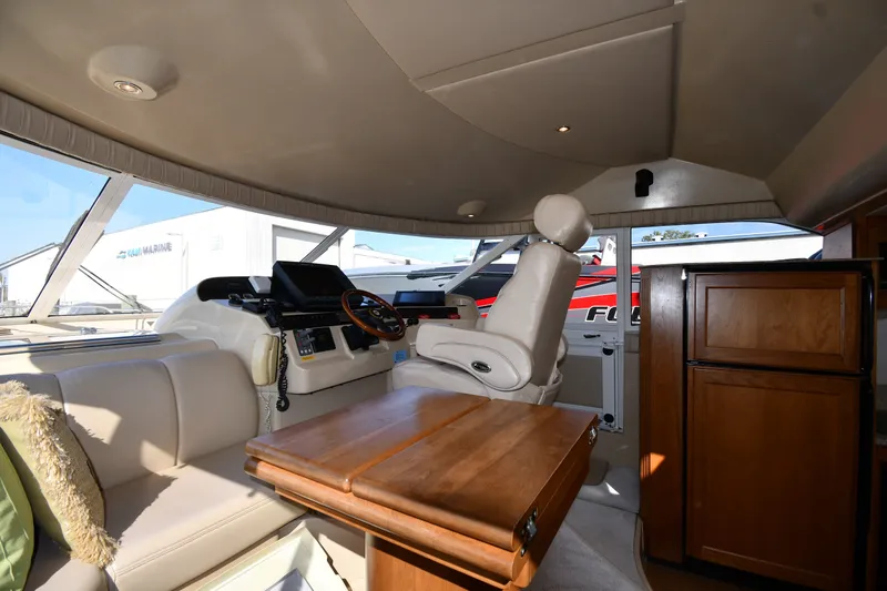 Slide: The Image of Interior of 2003 Cruisers Yachts 5000 Sedan Sport with helm, seating, and wooden cabinetry. - 67