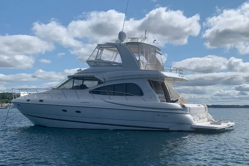 Slide: The Image of 2003 Cruisers Yachts 5000 Sedan Sport on calm water under a partly cloudy sky. - 1