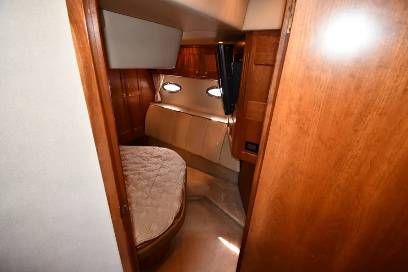 Slide: The Image of 2003 Cruisers Yachts 5000 Sedan Sport cabin interior with wood paneling and cozy bed. - 47