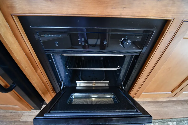 Slide: The Image of Open oven in 2003 Cruisers Yachts 5000 Sedan Sport kitchen area. - 64