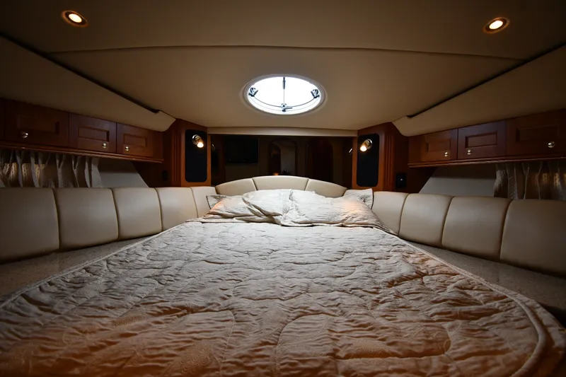 Slide: The Image of Luxurious interior cabin of 2003 Cruisers Yachts 5000 Sedan Sport with cozy bedding. - 37