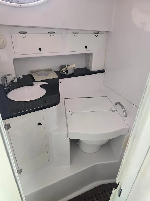 Slide: The Image of 2008 Donzi 38 ZSF boat bathroom with sink, storage cabinets, and toilet. - 13