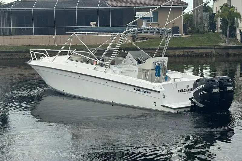 Slide: The Image of 2001 Contender 35 Side Console boat with dual Mercury engines on a calm waterway. - 3