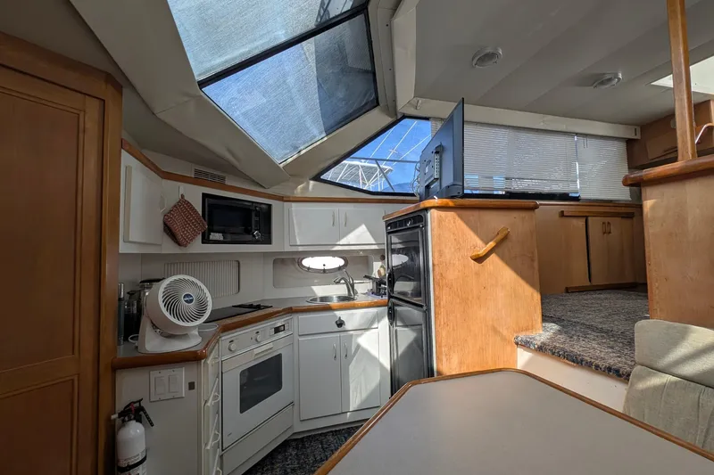 Slide: The Image of 1994 Carver 370 Aft Cabin Motor Yacht interior with kitchen and dining area. - 29