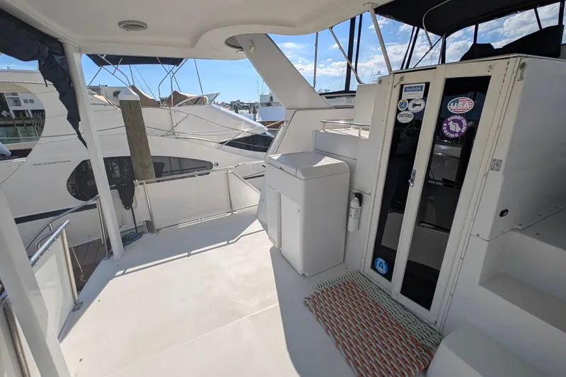 Slide: The Image of 1994 Carver 370 Aft Cabin Motor Yacht deck with seating and marina view. - 18