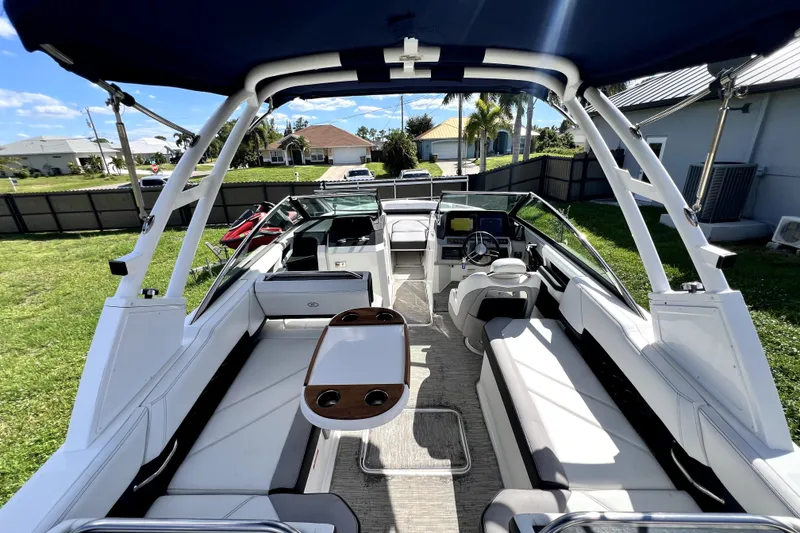 Slide: The Image of 2022 Cobalt R6 Outboard boat interior with seating and helm, parked on grass. - 54