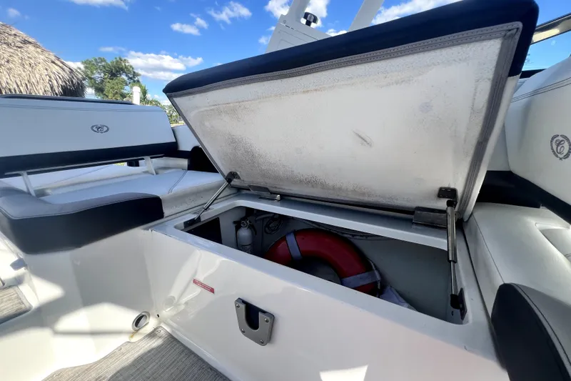 Slide: The Image of 2022 Cobalt R6 Outboard boat storage compartment with life preserver under open seat. - 65