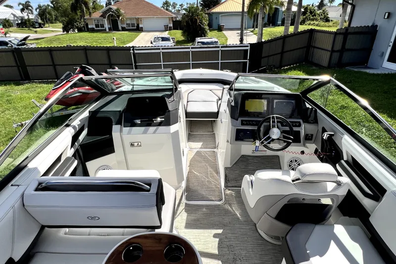 Slide: The Image of 2022 Cobalt R6 Outboard boat interior with modern dashboard and seating in a residential driveway. - 95