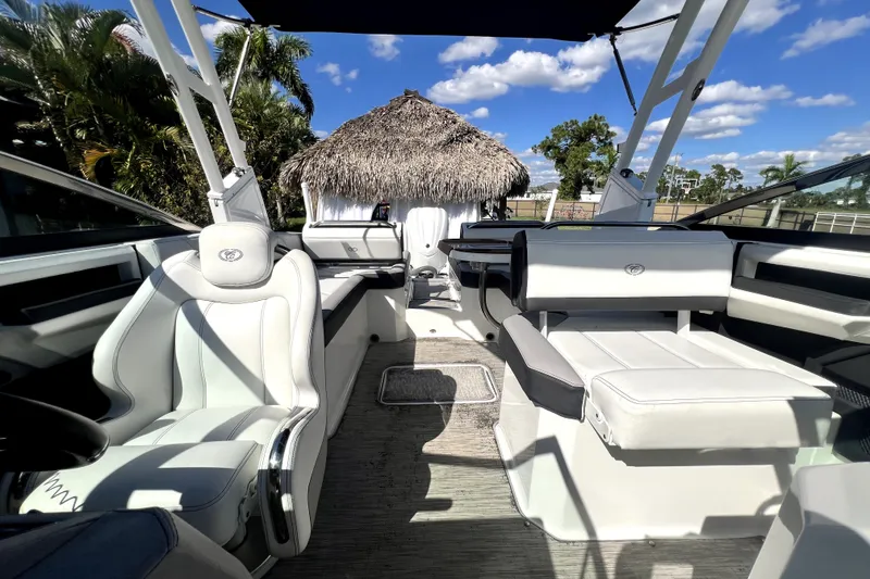 Slide: The Image of 2022 Cobalt R6 Outboard boat interior with white seating, tropical background, and clear blue sky. - 74