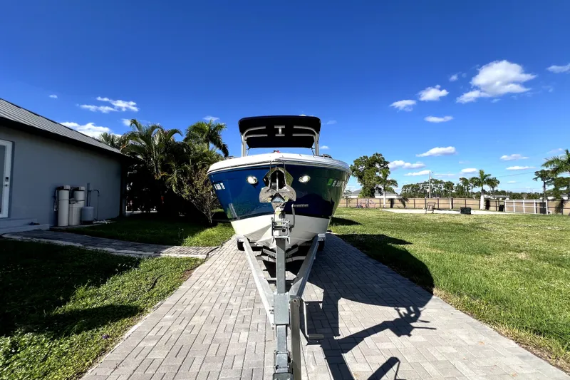 Slide: The Image of 2022 Cobalt R6 Outboard boat on trailer, sunny day, palm trees in background. - 14