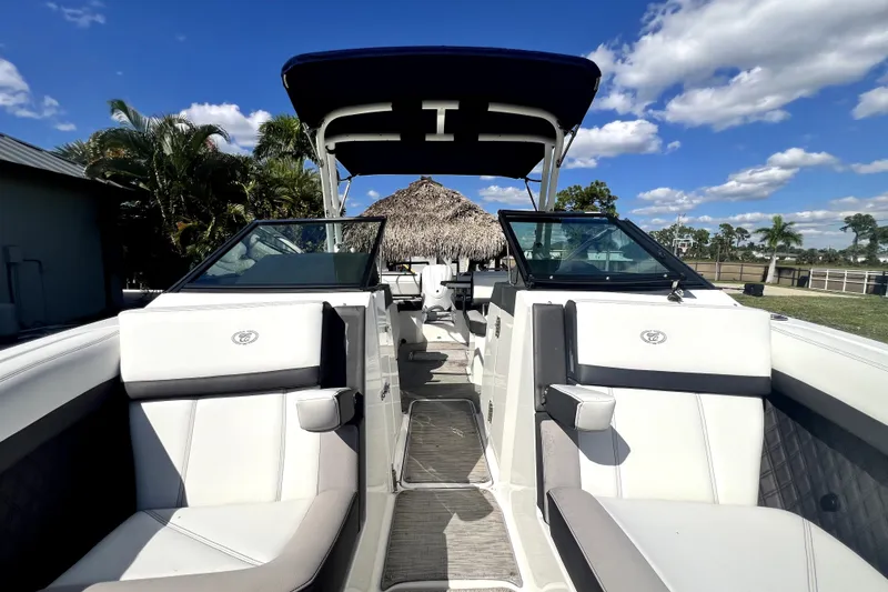 Slide: The Image of 2022 Cobalt R6 Outboard boat interior with white seating, under a clear blue sky. - 77