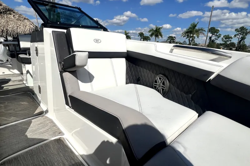 Slide: The Image of 2022 Cobalt R6 Outboard boat interior with luxurious seating and speaker, under a sunny sky. - 78