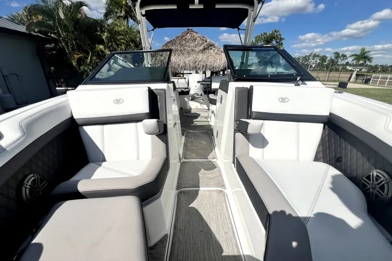 Slide: The Image of 2022 Cobalt R6 Outboard boat interior with white seating and open deck under blue sky. - 80