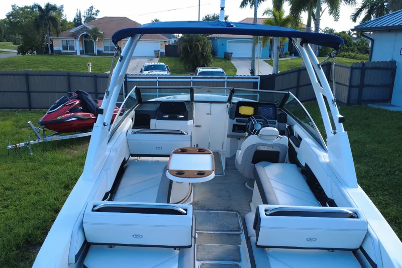 Slide: The Image of 2022 Cobalt R6 Outboard boat with spacious seating and modern dashboard, parked in a residential yard. - 20