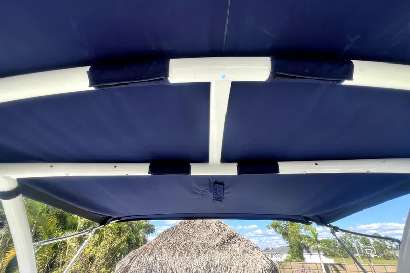 Slide: The Image of 2022 Cobalt R6 Outboard boat canopy with blue fabric and white frame. - 39