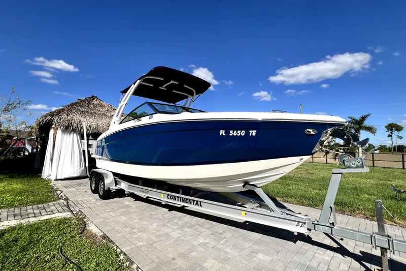 Slide: The Image of 2022 Cobalt R6 Outboard boat on trailer, parked outdoors under clear blue sky. - 13