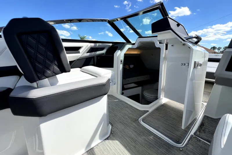 Slide: The Image of 2022 Cobalt R6 Outboard boat interior with open cabin door under a clear blue sky. - 91