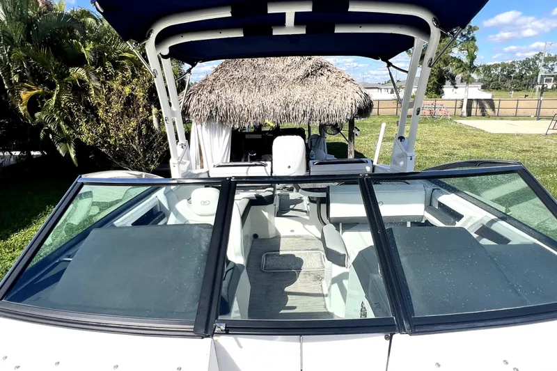 Slide: The Image of 2022 Cobalt R6 Outboard boat with canopy, parked near tropical greenery. - 42