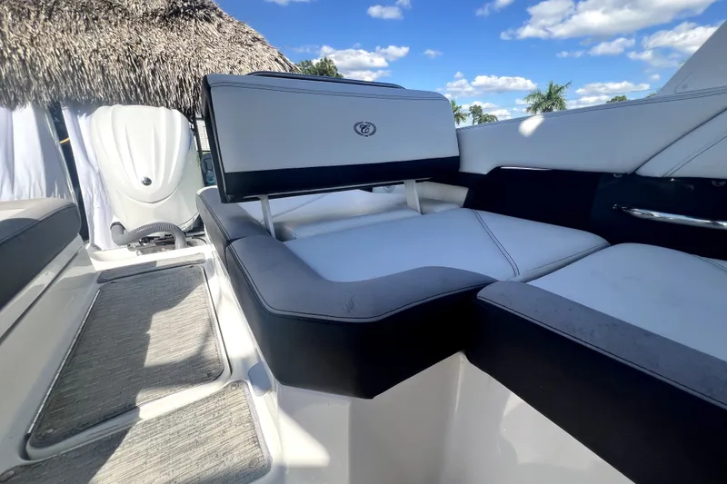 Slide: The Image of 2022 Cobalt R6 Outboard boat interior with plush seating and sleek design under a sunny sky. - 63