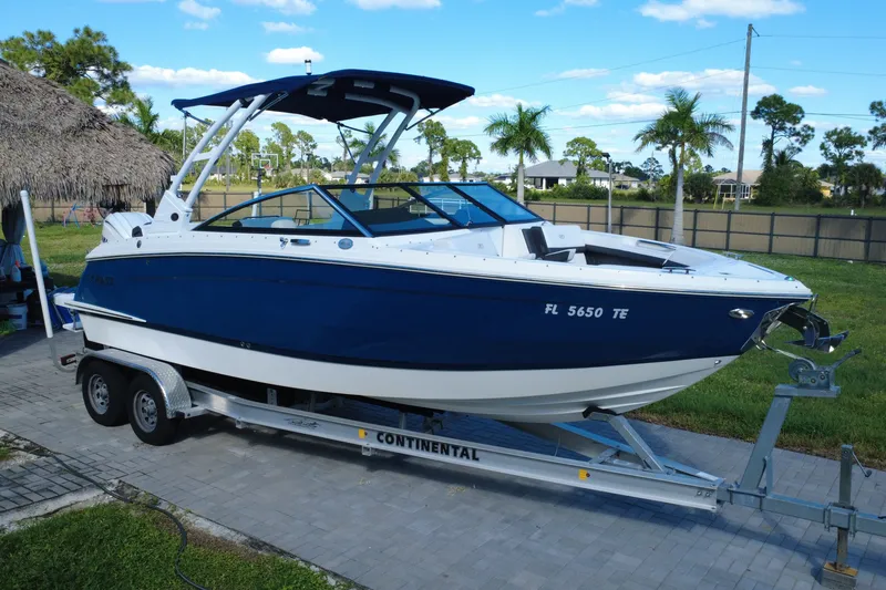 The Image of 2022 Cobalt R6 Outboard boat on trailer, parked outdoors with palm trees in background. - 0