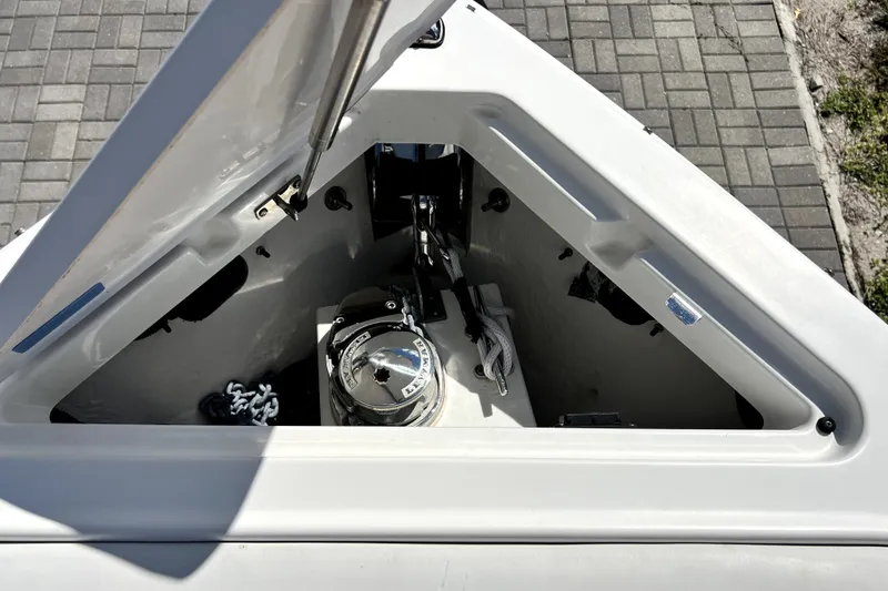 Slide: The Image of Open anchor compartment of 2022 Cobalt R6 Outboard boat with visible chain and winch. - 46