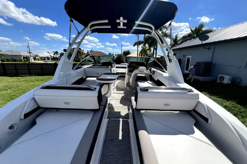 Slide: The Image of 2022 Cobalt R6 Outboard boat interior with seating and canopy under a sunny sky. - 29