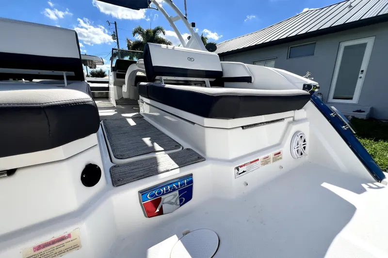 Slide: The Image of 2022 Cobalt R6 Outboard boat interior with seating and logo, under a clear blue sky. - 55