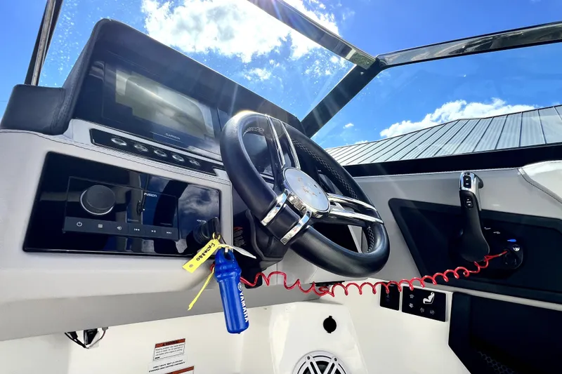 Slide: The Image of 2022 Cobalt R6 Outboard dashboard with steering wheel and controls under a clear blue sky. - 88