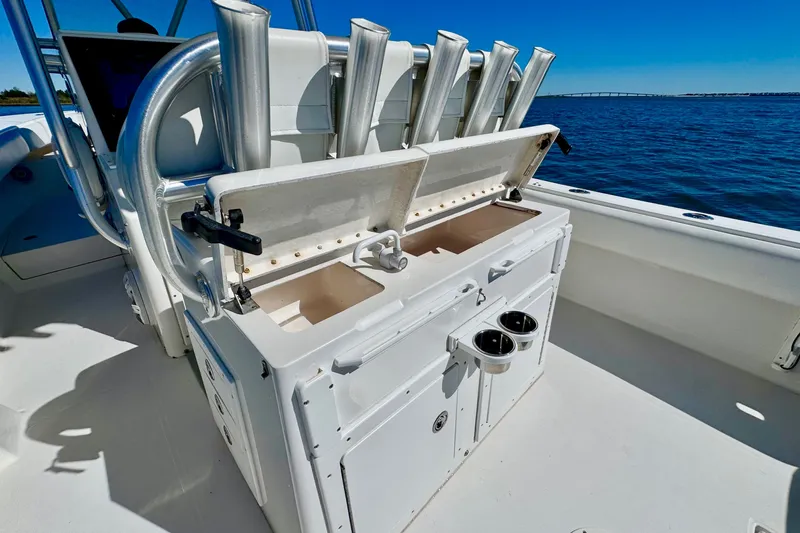 Slide: The Image of 2005 Regulator 32 Forward Seating boat with open storage compartment and rod holders on deck. - 25
