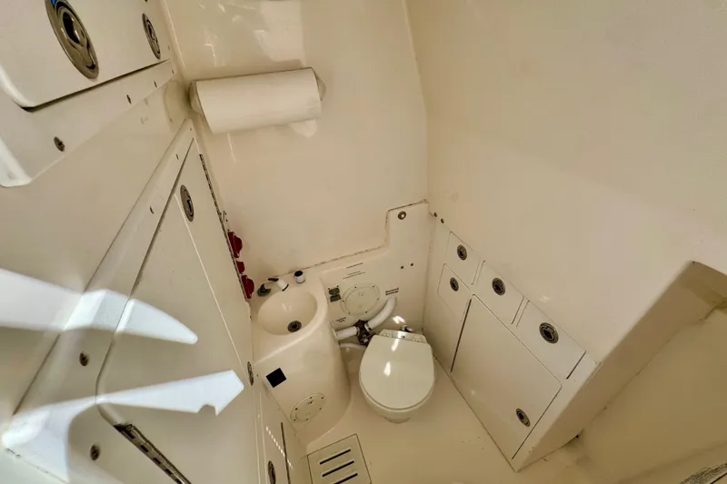 Slide: The Image of Interior of a 2005 Regulator 32 Forward Seating boat, featuring a compact marine toilet. - 29