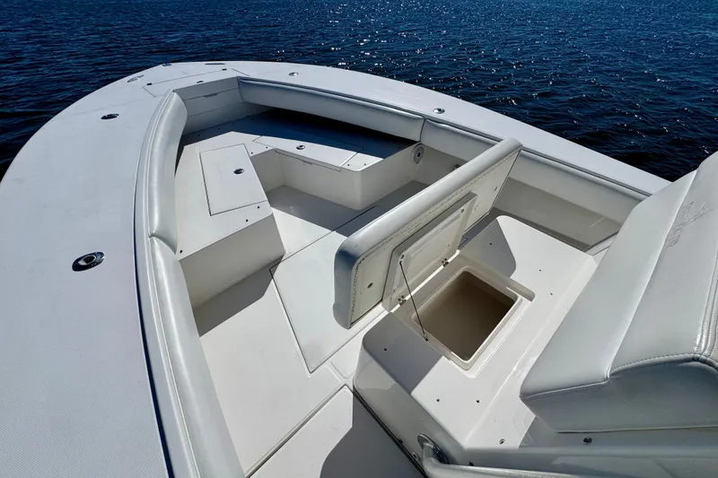 Slide: The Image of 2005 Regulator 32 Forward Seating boat interior with open storage compartment on calm water. - 20