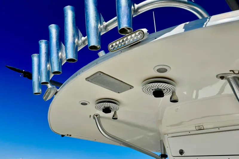 Slide: The Image of 2005 Regulator 32 Forward Seating boat with rod holders and speakers against clear blue sky. - 14