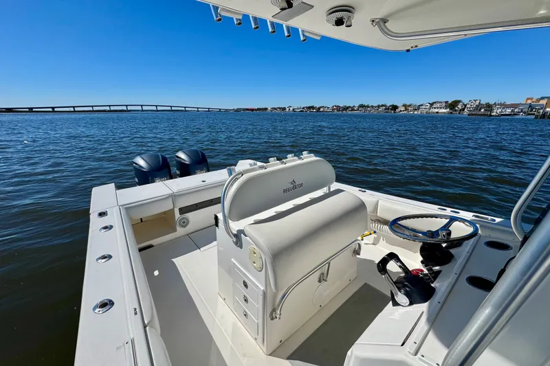 Slide: The Image of 2005 Regulator 32 Forward Seating boat on calm water with clear blue sky. - 18