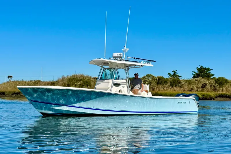 The Image of 2005 Regulator 32 Forward Seating boat on calm water under clear blue sky. - 0