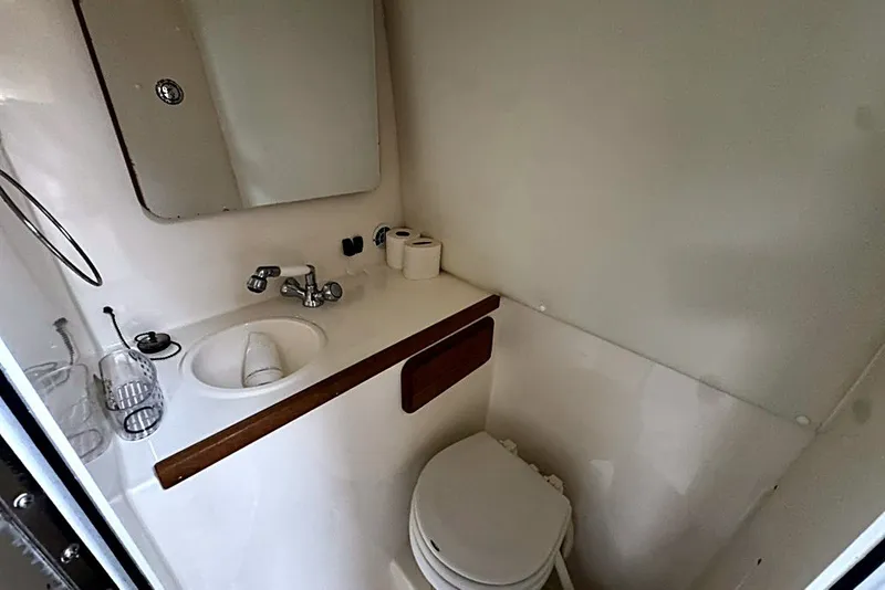 Slide: The Image of Compact bathroom in 2003 Contender 35 Side Console boat with sink and toilet. - 15