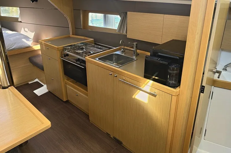 Slide: The Image of Interior of 2014 Beneteau Oceanis 38 yacht kitchen with stove, sink, and wooden cabinetry. - 17
