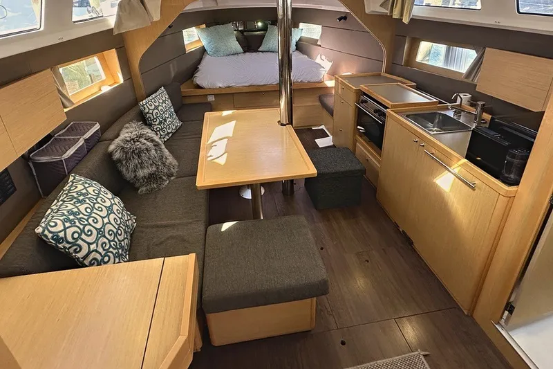 Slide: The Image of Interior of 2014 Beneteau Oceanis 38 yacht with cozy seating, dining area, and compact kitchen. - 13