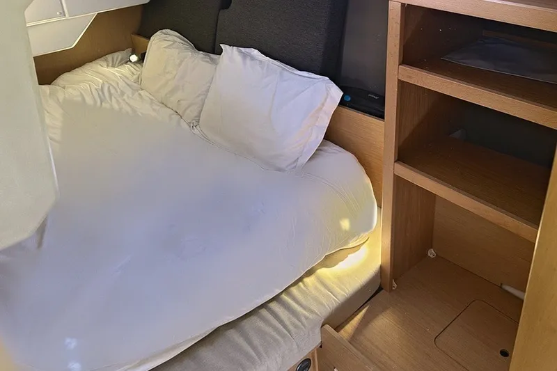 Slide: The Image of Cozy cabin interior of 2014 Beneteau Oceanis 38 sailboat with bed and wooden shelves. - 18