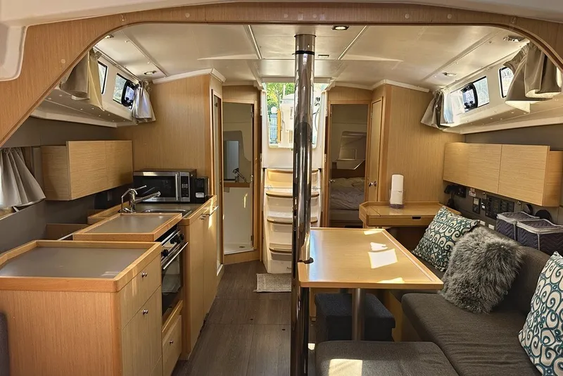 Slide: The Image of Interior of a 2014 Beneteau Oceanis 38 sailboat, featuring a modern kitchen and cozy seating area. - 15