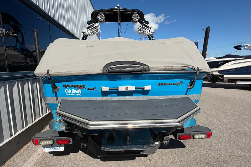 Slide: The Image of 2016 Supra SG 400-550 boat with cover, parked outdoors, featuring Raptor engine branding. - 17