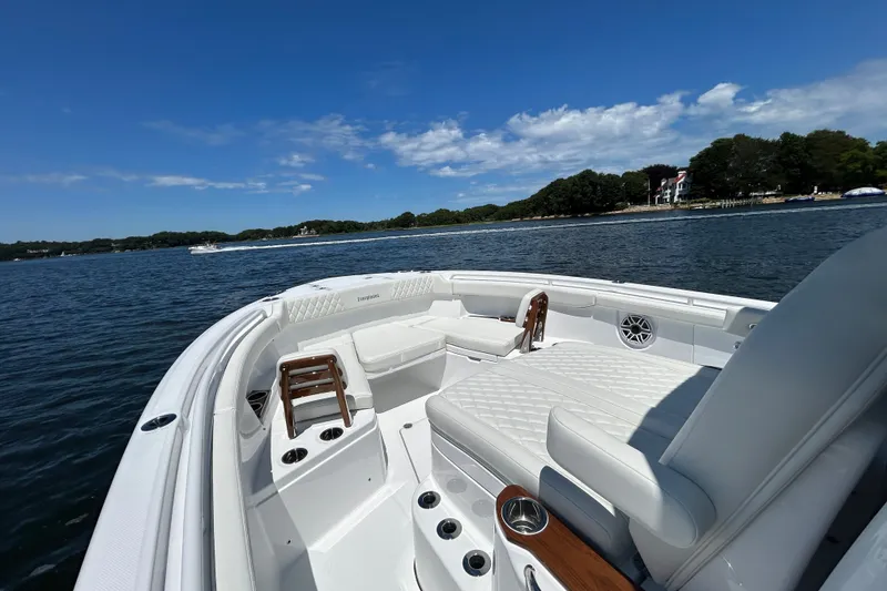 Slide: The Image of 2027 Everglades 315 Center Console boat on calm water, featuring luxurious seating and clear skies. - 28