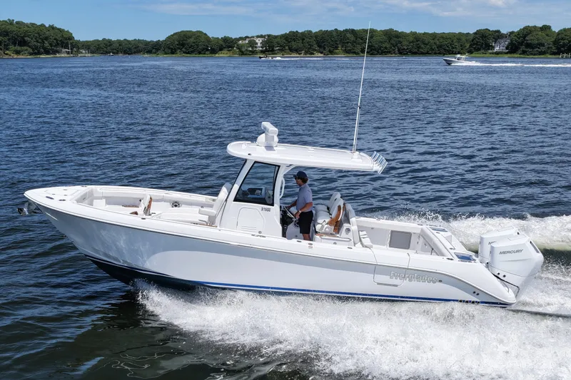 The Image of 2027 Everglades 315 Center Console boat cruising on a scenic waterway. - 1